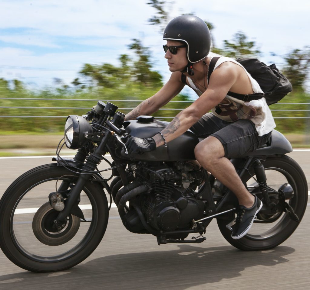 man-with-backpack-riding-motorcycle-on-road.jpg